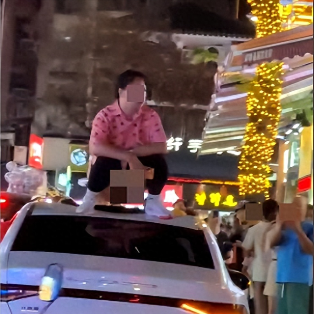 桂林一女子爬上车顶当街脱裤子,周围商户称人被带走
